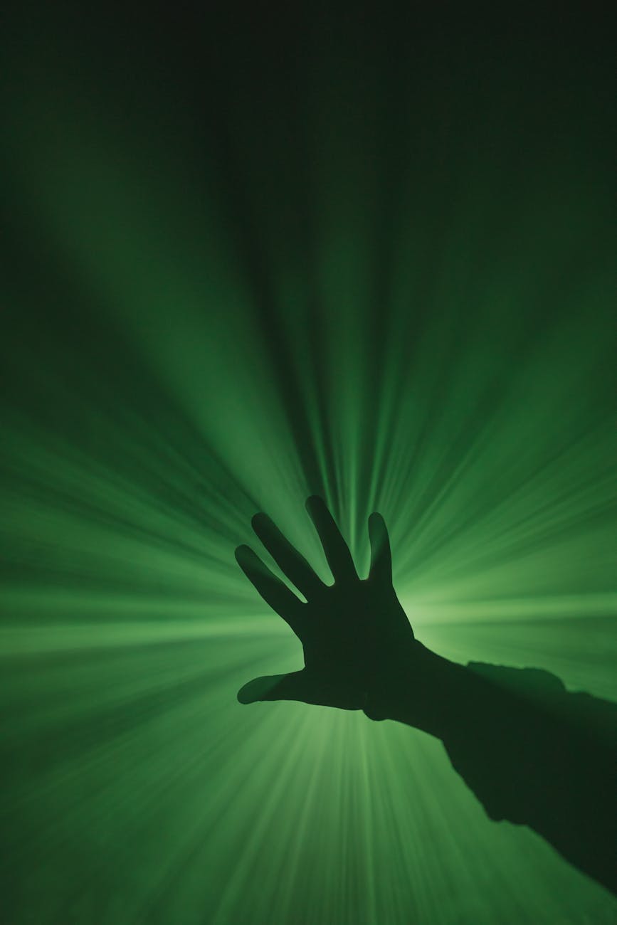 Silhouette of a person meditating with an abstract green energy flow